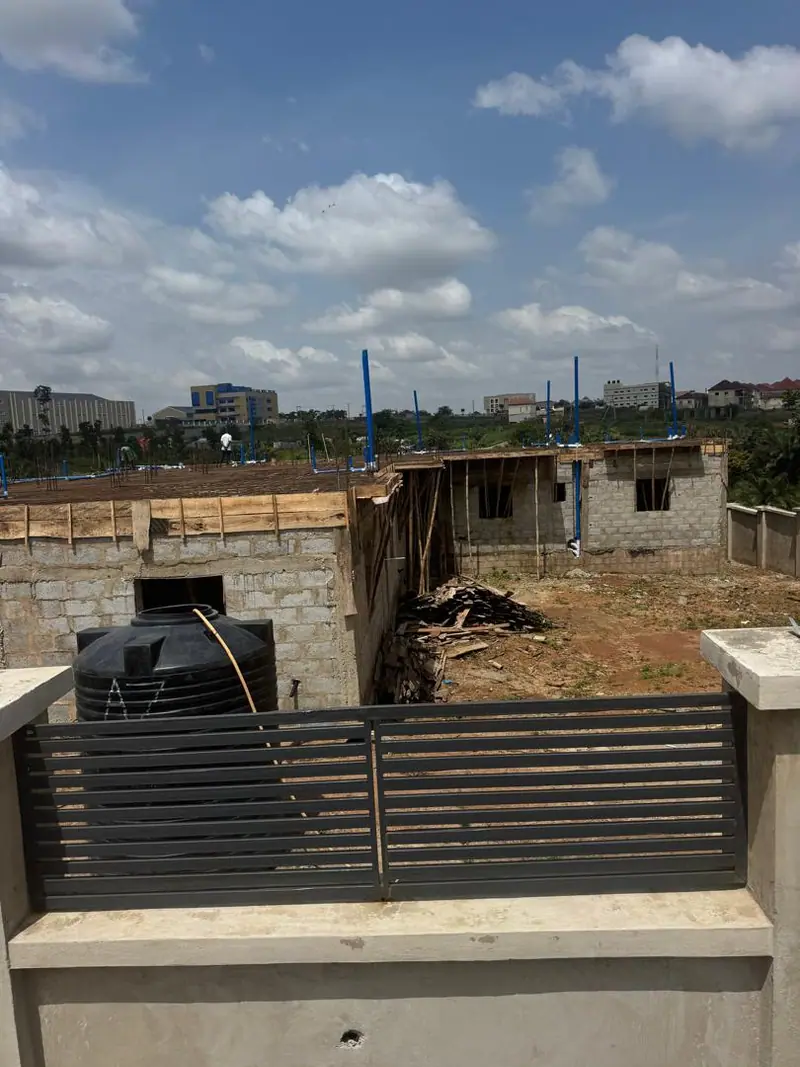 A finished fence and gate in front of a building at blockwork stage