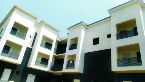 A completed white block with recessed balconies and glass railings
